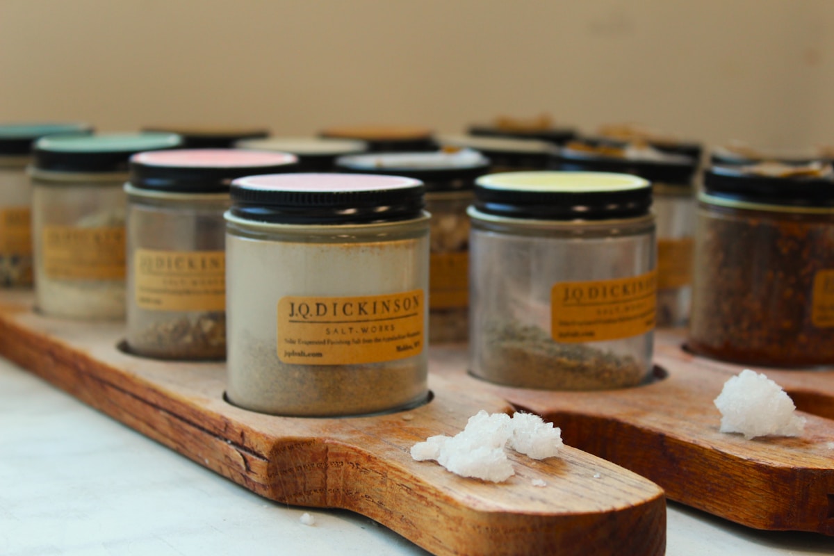 A wooden tray topped with lots of different types of spices